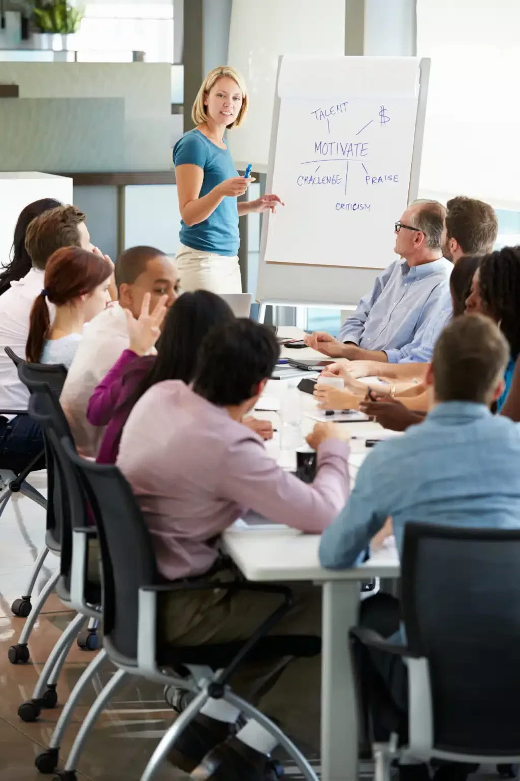 Businesswoman Addressing Meeting Around Boardroom Table